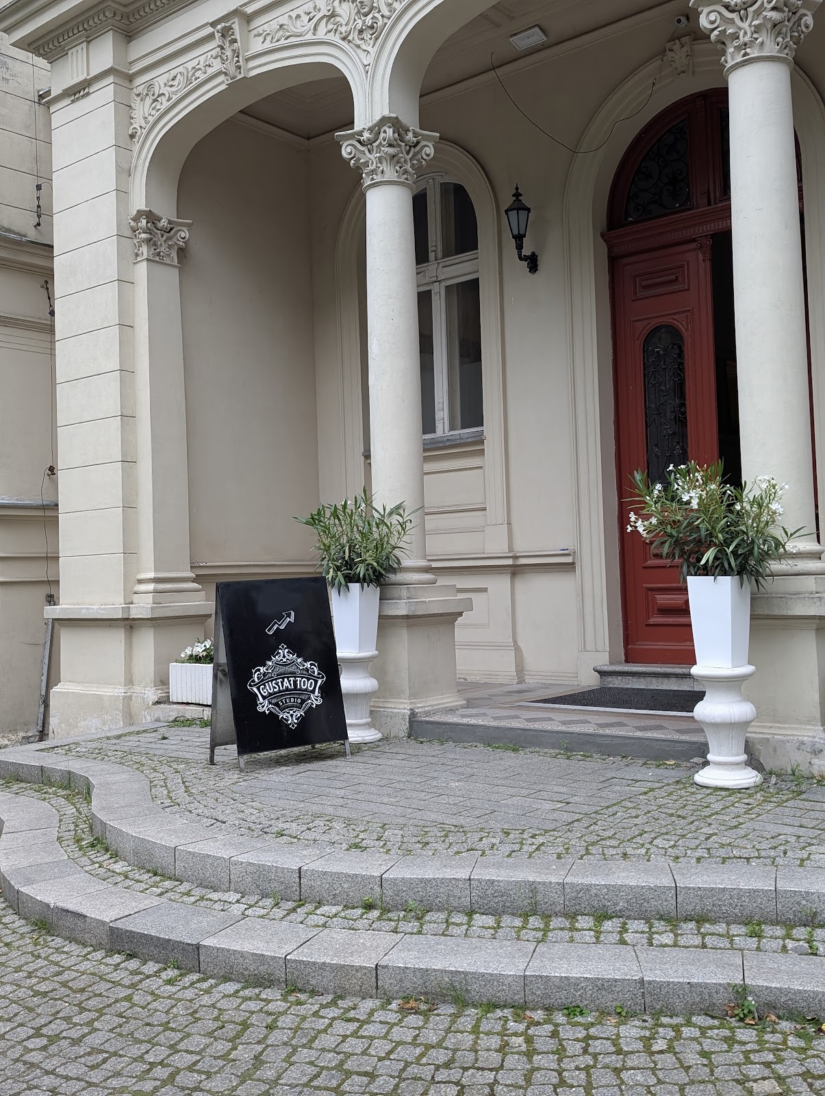 Wejście do Pałacu Ksawerów - kolumnada i czerwone drzwi prowadzące do studia Gustattoo